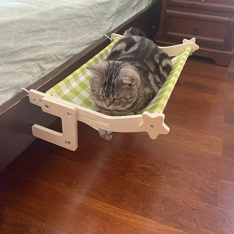 A Snuggle Cat Bed Nest with a green checkered design, creating a cozy and soft resting space for cats under the bed.