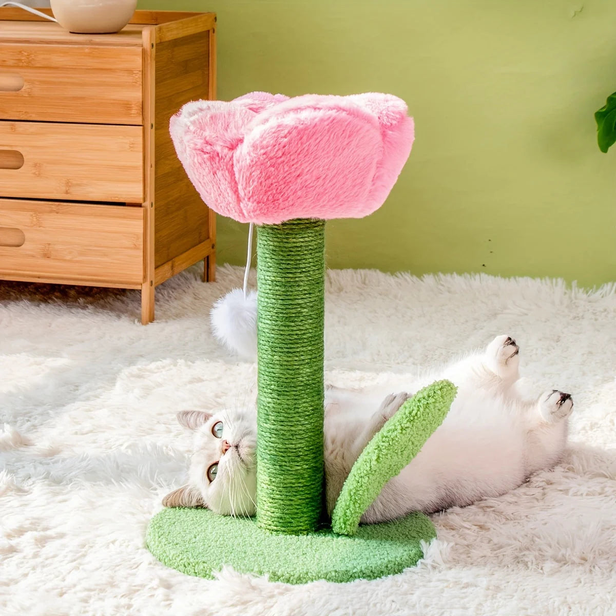 Cat playfully laying down next to a DIY cat scratching post, enjoying the soft pink flower design