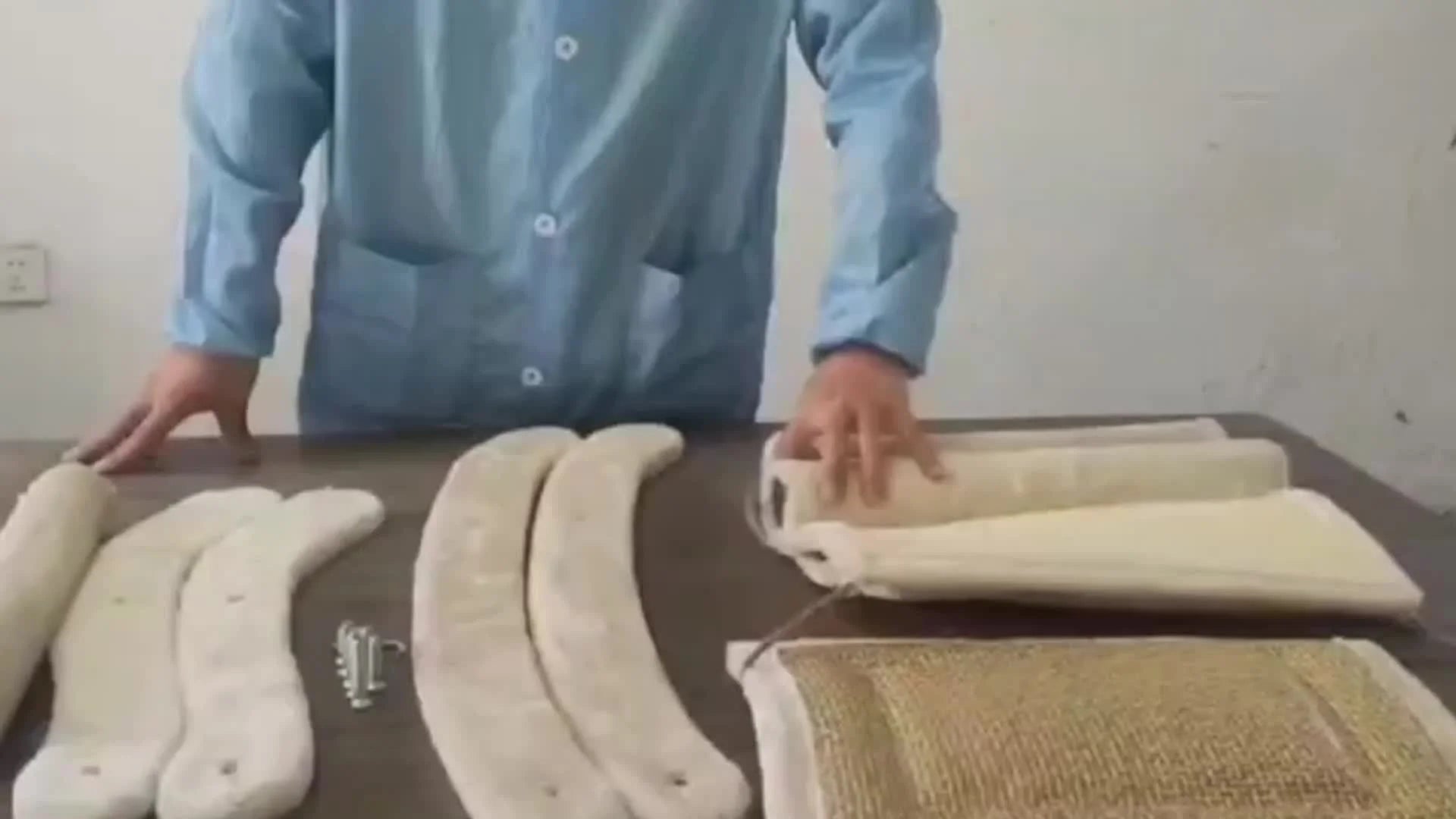 Playful cat interacting with a hanging fluff ball toy on a cat scratching post with bed.