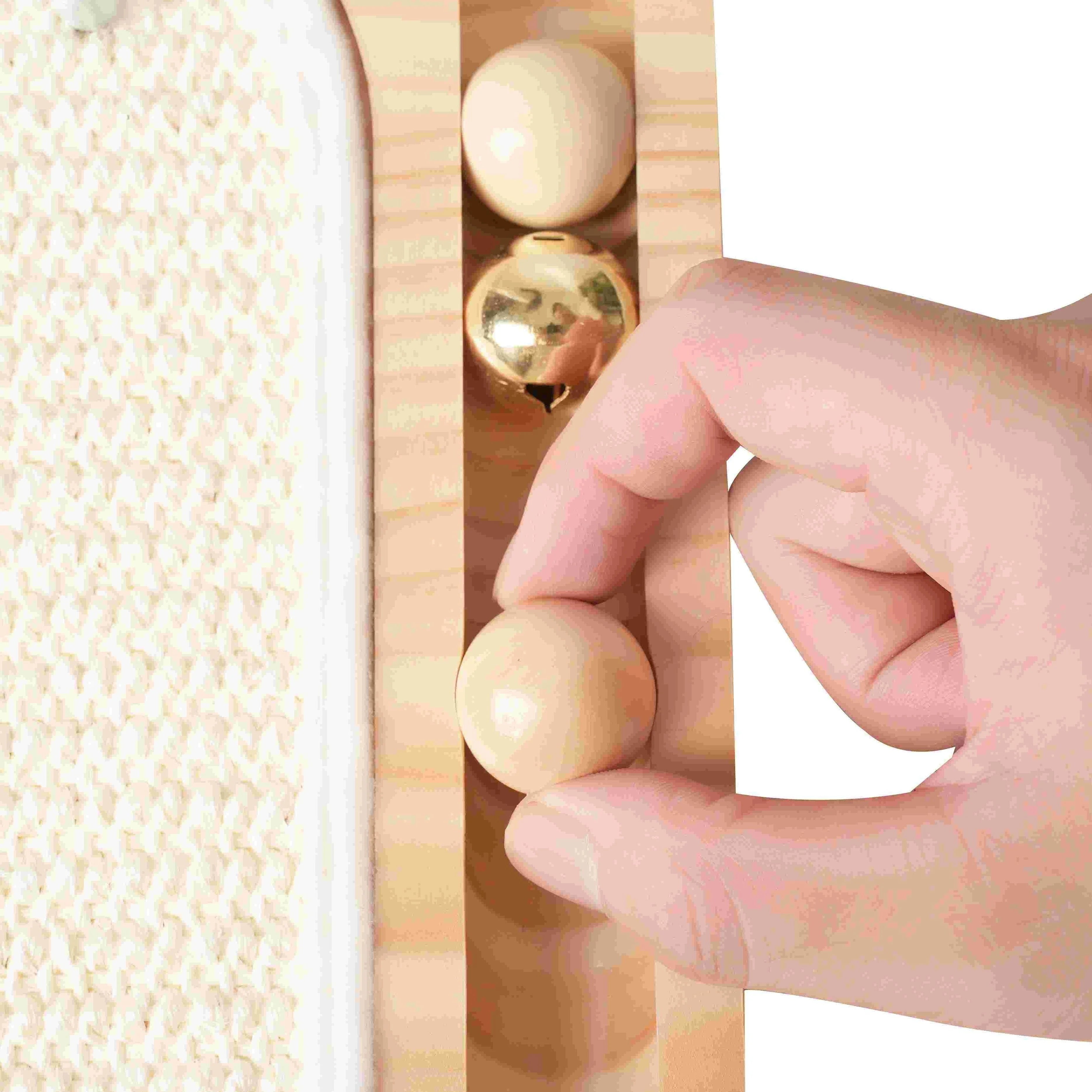 Close-up view of a hand demonstrating the interactive track balls included in the cat scratching post for large cats.