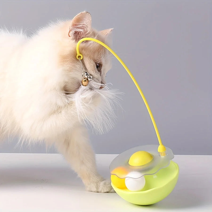 A fluffy cat interacting with a yellow cat toy feather wand, engaging with the dangling feather.