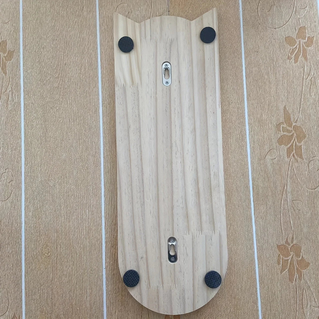 Back view of a cat wall scratching post revealing mounting hardware and protective pads.