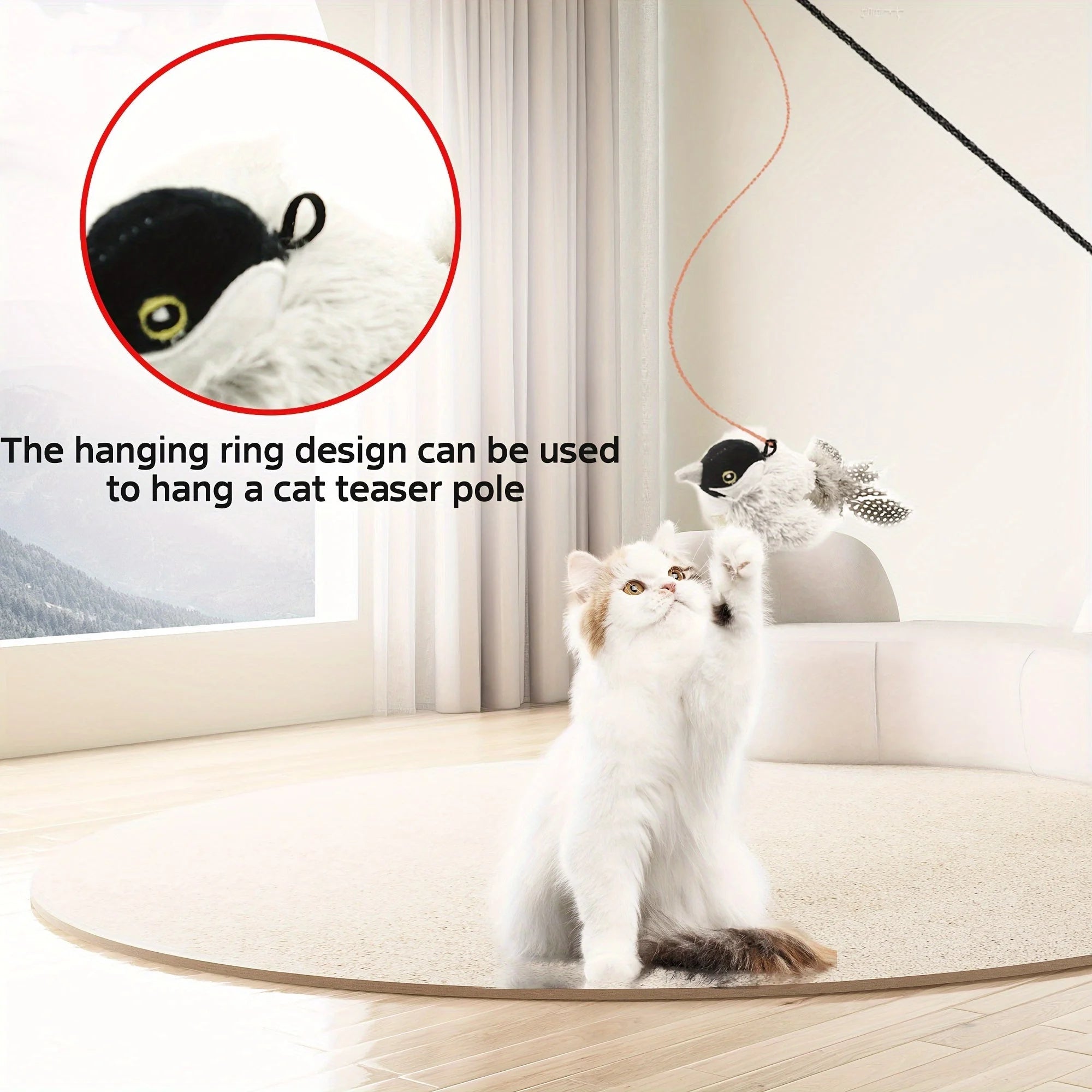 White cat jumping to swat a black and white chirping bird cat toy hanging on a string.
