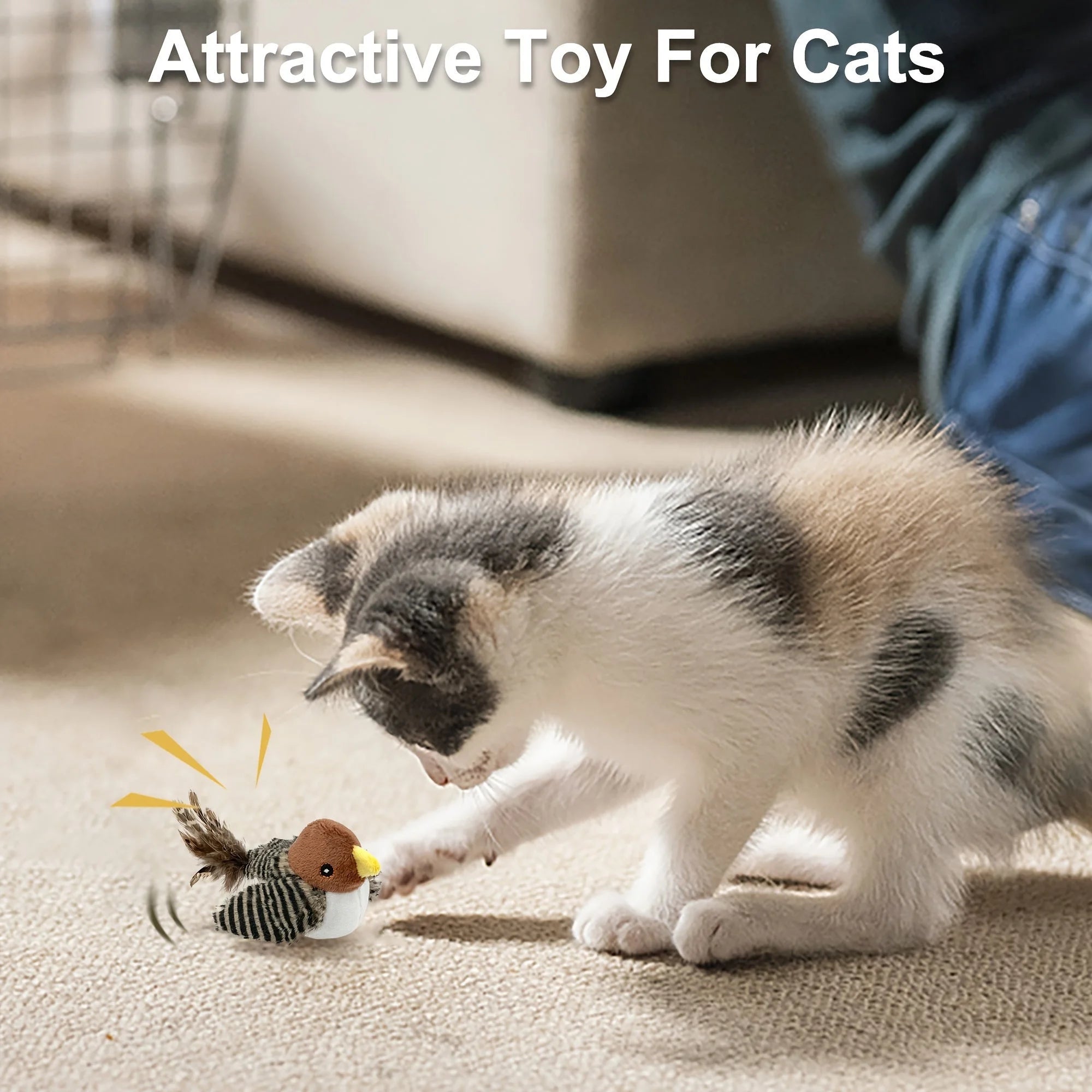 Kitten playing with a chirping bird cat toy on a carpeted floor.