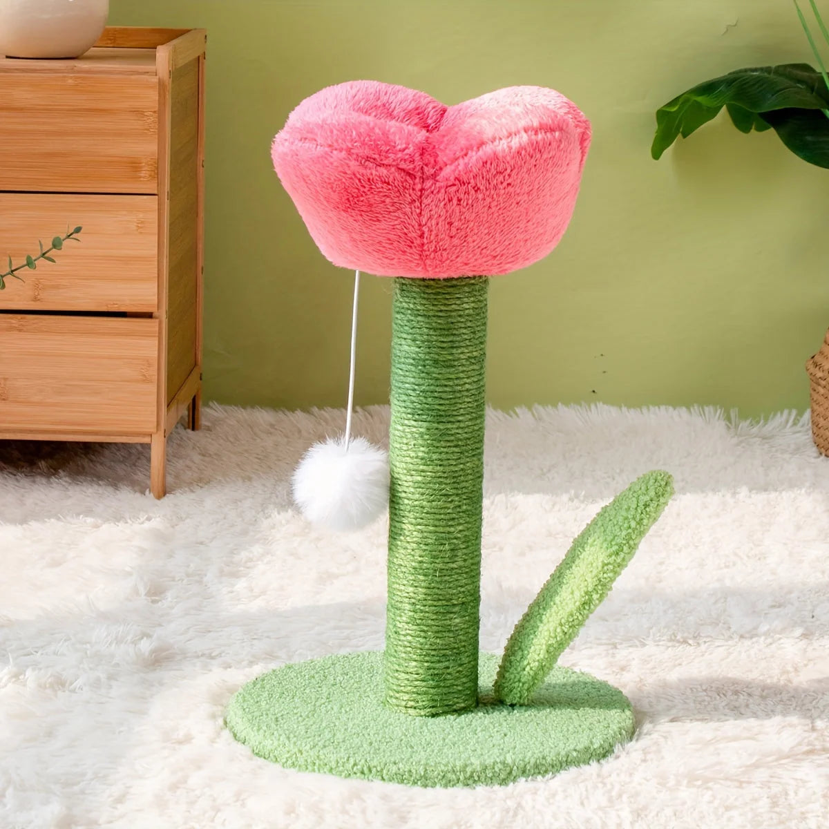 Pink flower-shaped DIY cat scratching post with a playful pom-pom on a cozy carpet.