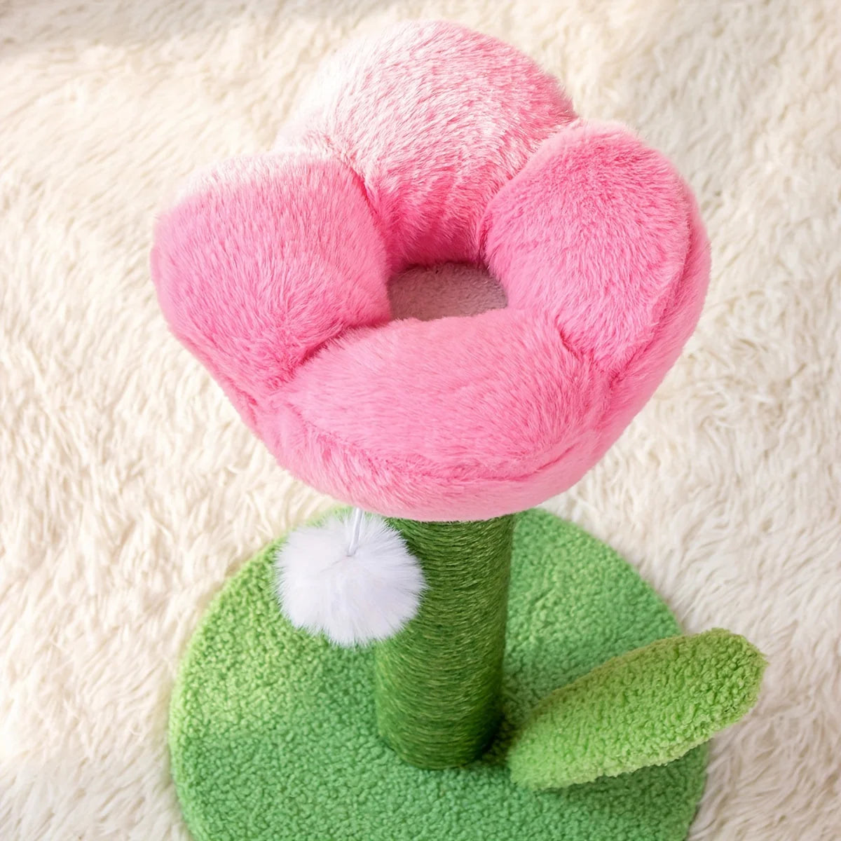 Top view of the soft pink flower-shaped bed of a DIY cat scratching post.