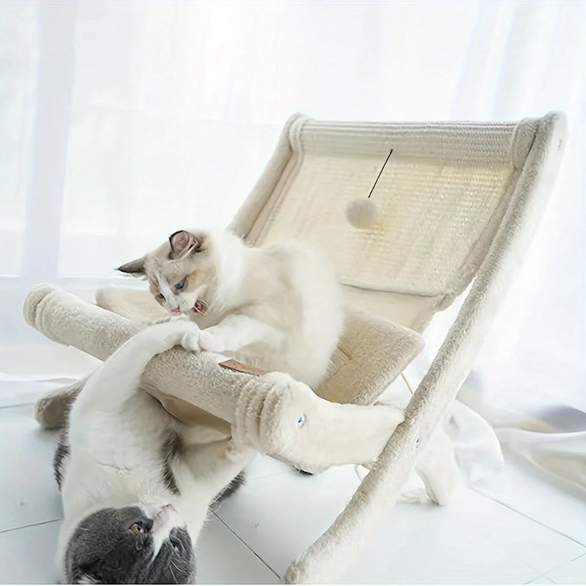 Cat scratching on sisal hemp surface and playing with fluff balls attached to the cat scratching post with bed.