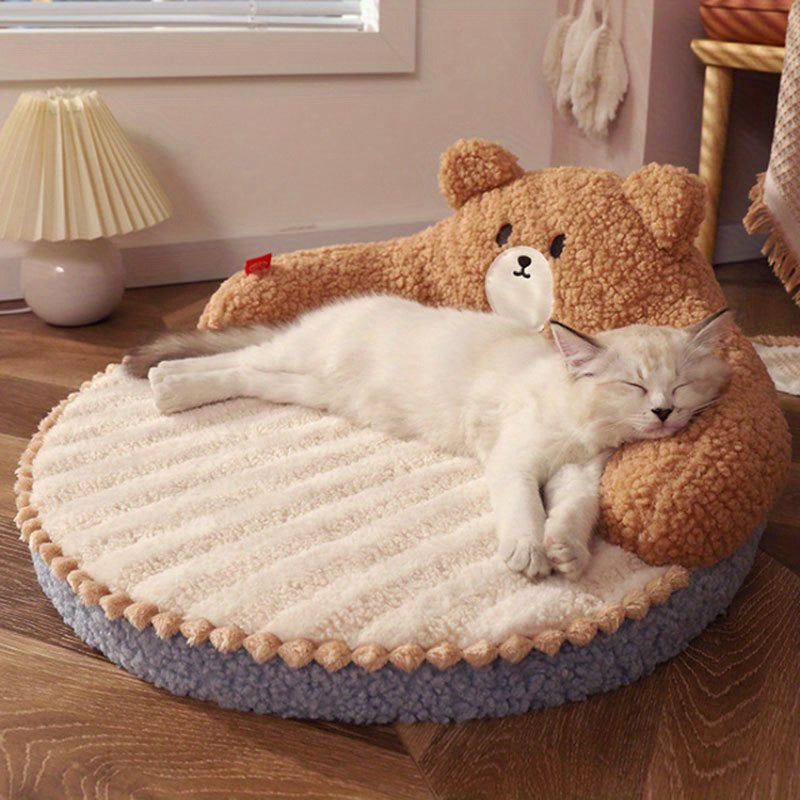 A plush blue and pink cat bed featuring an adorable bear face design and a relaxed kitten, perfect as an outdoor cat bed.