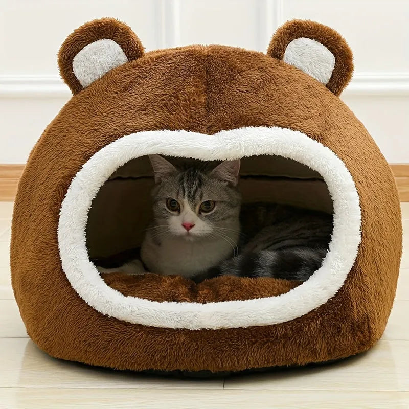 A comfortable cat inside a plush, bear-themed warm cat bed