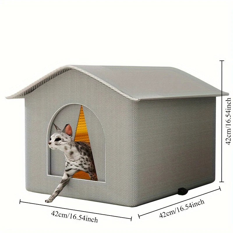 A cat emerges from a small, grey, house-shaped cat bed. The bed features an arched doorway and has dimensions listed as 42cm (16.54 inches) in both height and width.