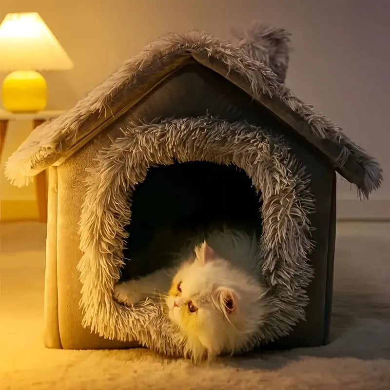 Cat resting inside a cozy grey covered cat bed with a fluffy entrance.