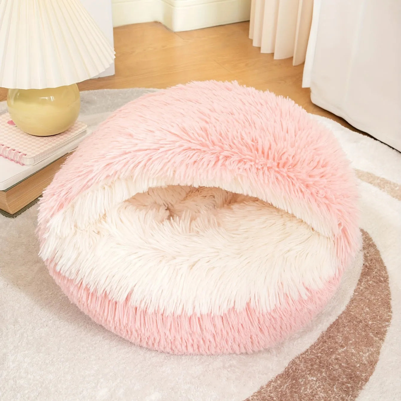 A pink self-heating cat bed with fluffy faux fur, perfect for small pets.