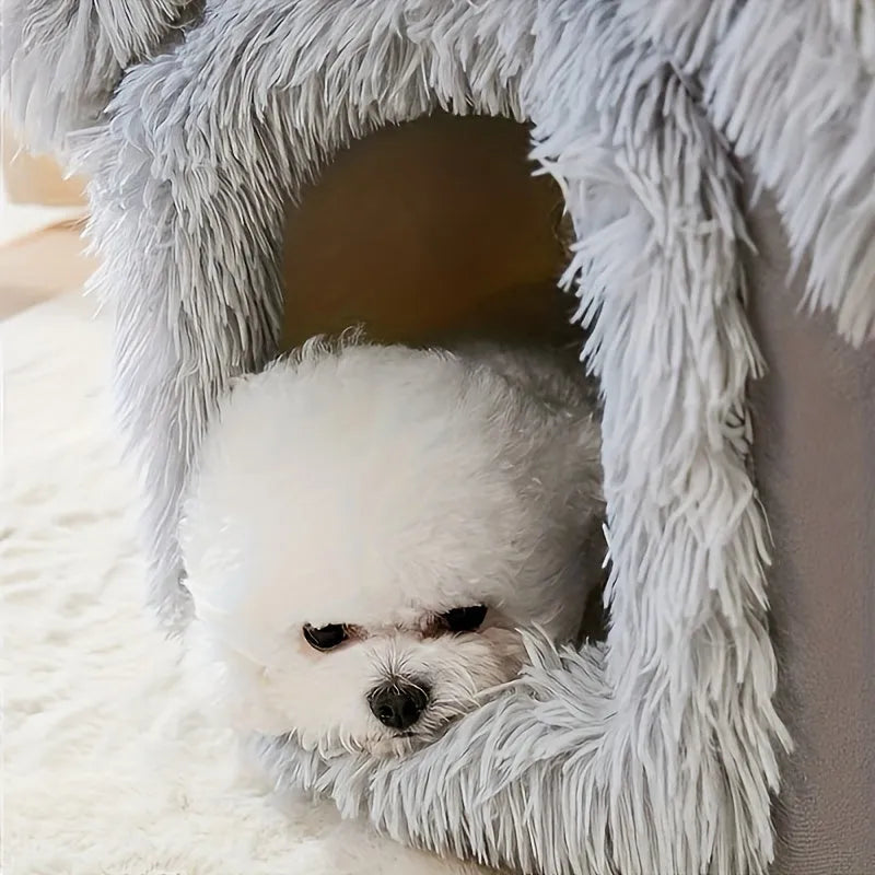 Dog peeking out from a soft and fluffy grey covered cat bed.