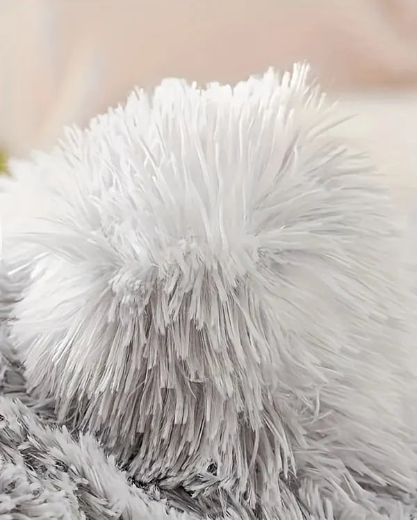 Close-up of the fluffy roof of a grey covered cat bed showcasing its soft texture.