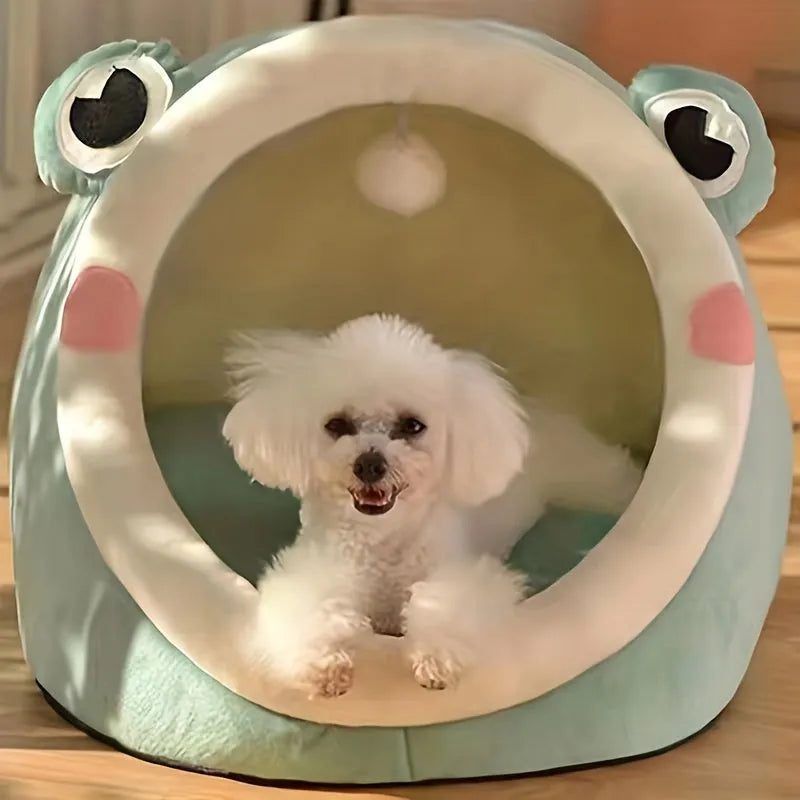 A playful frog-shaped covered cat bed, suitable for cats and small dogs, with a hanging pom-pom toy.