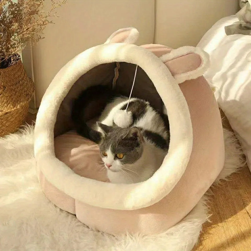 A pink covered cat bed with soft plush lining and a cute design, perfect for cats to relax in comfort.