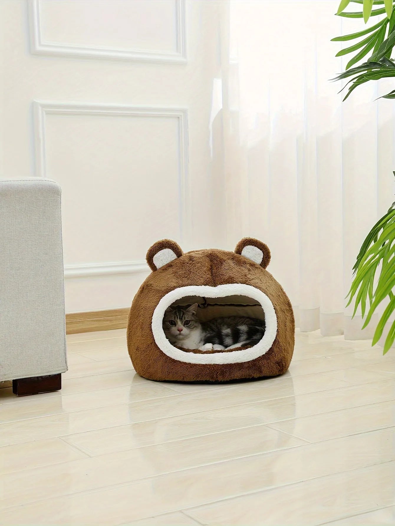 A warm cat bed with a bear design placed in a modern room setting.