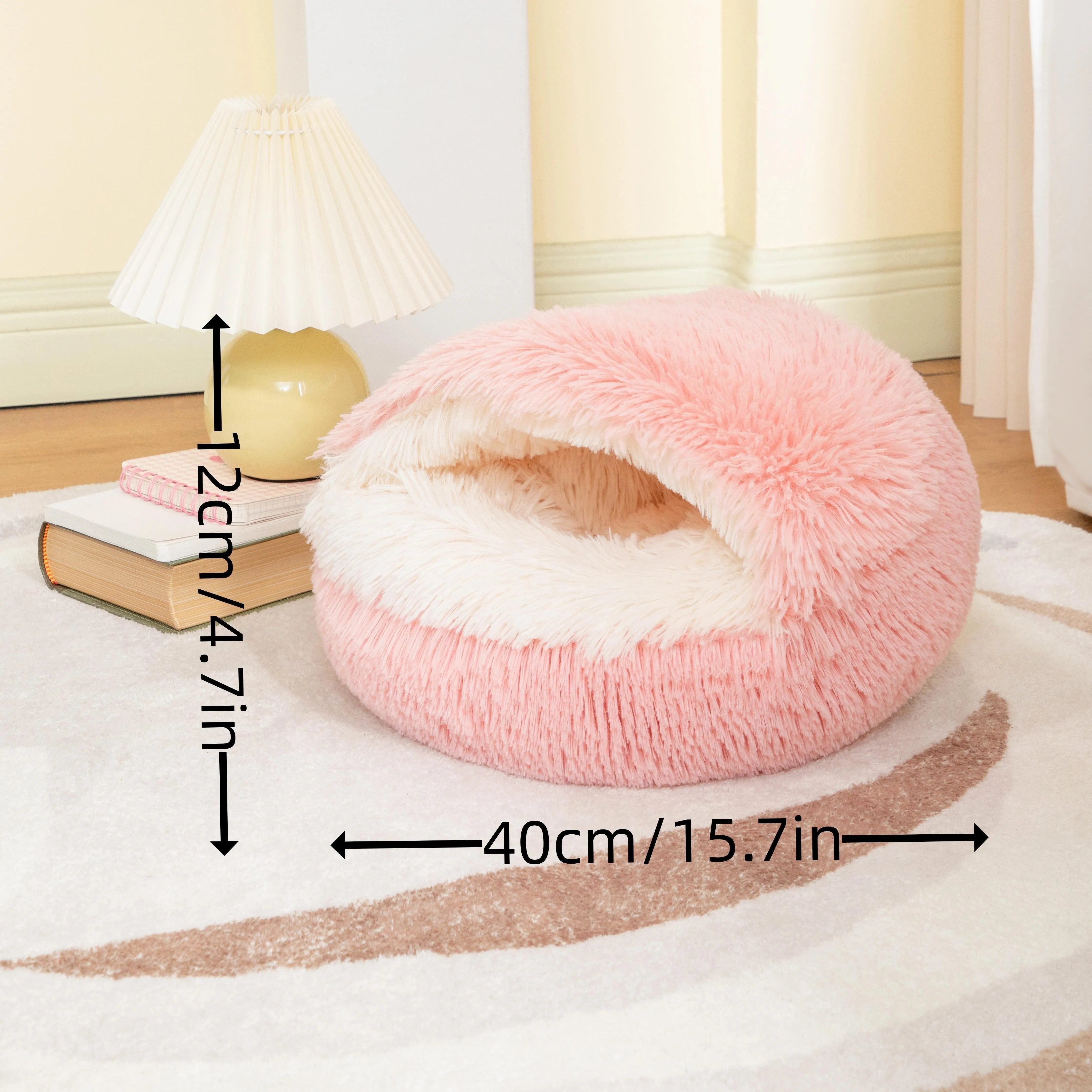 A pink self-heating cat bed with dimensions labeled as 40cm/15.7in in diameter and 12cm/4.7in in height.