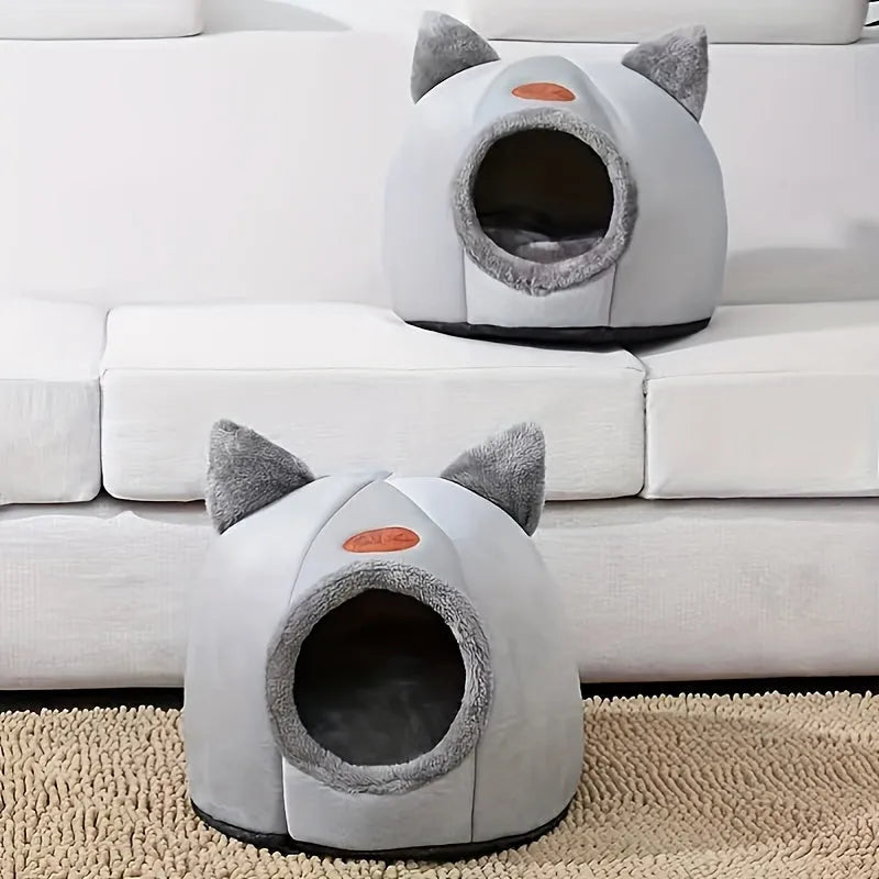 A set of two indoor heated cat beds placed on a beige carpet, designed for warmth and comfort.